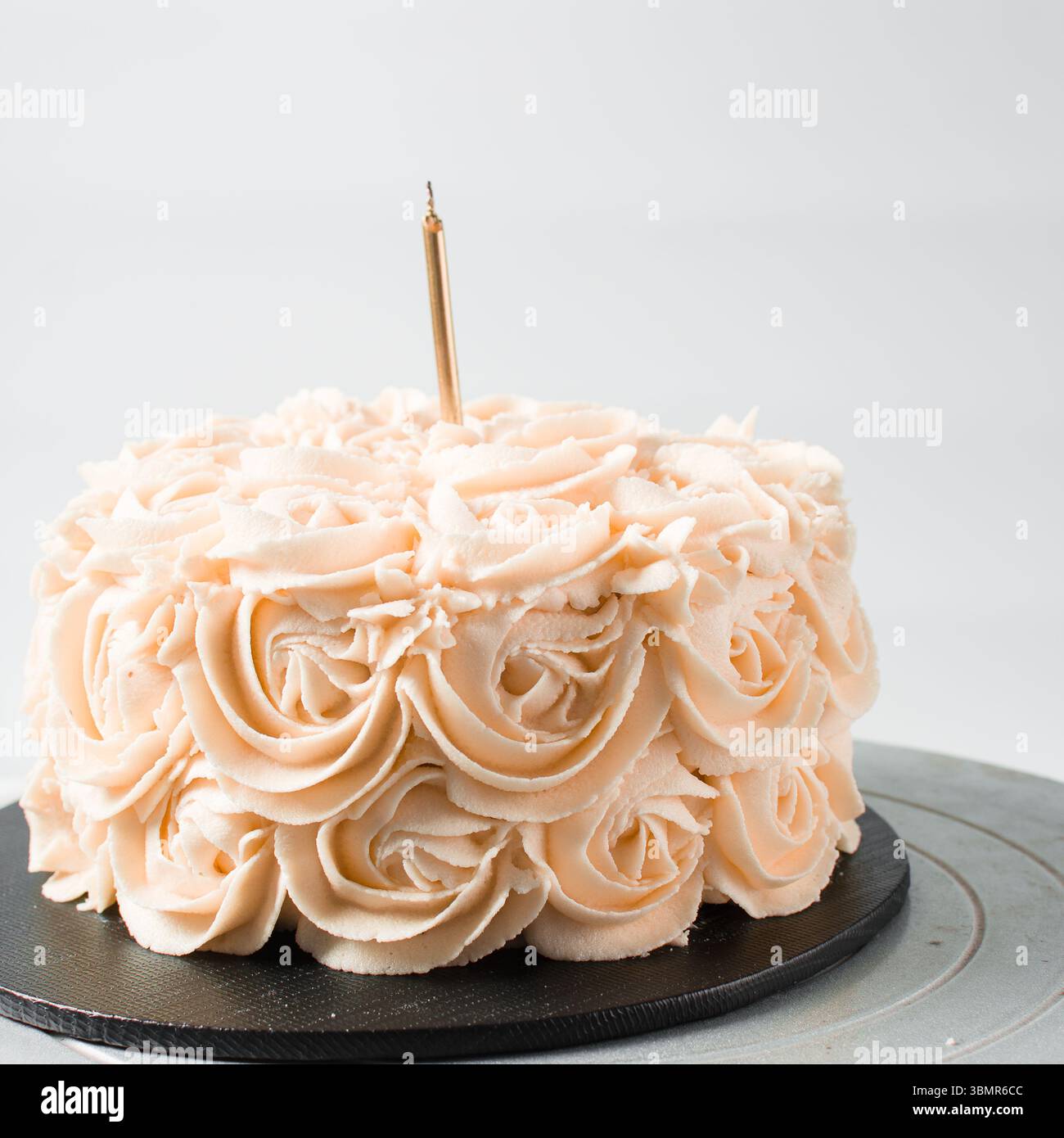 Gâteau de rosette de crème au beurre sur un stand de gâteau, gâteau couvert de rosettes de crème au beurre, processus de décoration d'un gâteau avec des roses Banque D'Images