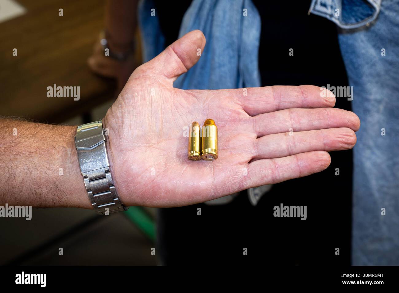 Landkreis Osnabrück, Deutschland 25. Juni 2025 : Im Bild : eine offene Handfläche hält zwei unterschiedliche Patronen für Handfeuerwaffen, um deren Größenunterschied zu demonstrieren. Die Patronen sind aus glänzendem Messing gefertigt und bestehen aus Hülse, Geschoss und Zündhütchen. DAS Bild betont die physischen Eigenschaften von scharfer munition und ihre Rolle im Sportschießen oder BEI der Jagd. Die Details der hand und der Armbanduhr lenken den Blick auf die Präsentation der munition. Landkreis Osnabrück Niedersachsen *** District de Osnabrück, Allemagne 25 juin 2025 dans la photo an open PA Banque D'Images