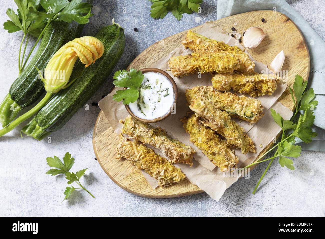Collation saine et savoureuse, repas d'été. Frites de courgettes. Bâtonnets de courgettes croustillantes dans de la chapelure, avec du fromage et de la saucisse au yaourt à l'ail. Vue de dessus Banque D'Images
