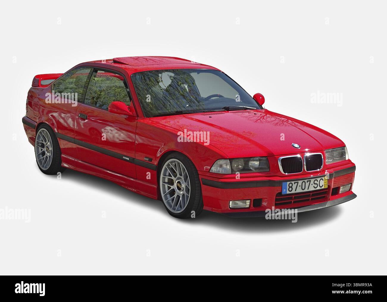 Parking rouge brillant BMW M3 E36 sur fond blanc, mettant en valeur son design sportif et son look emblématique Banque D'Images