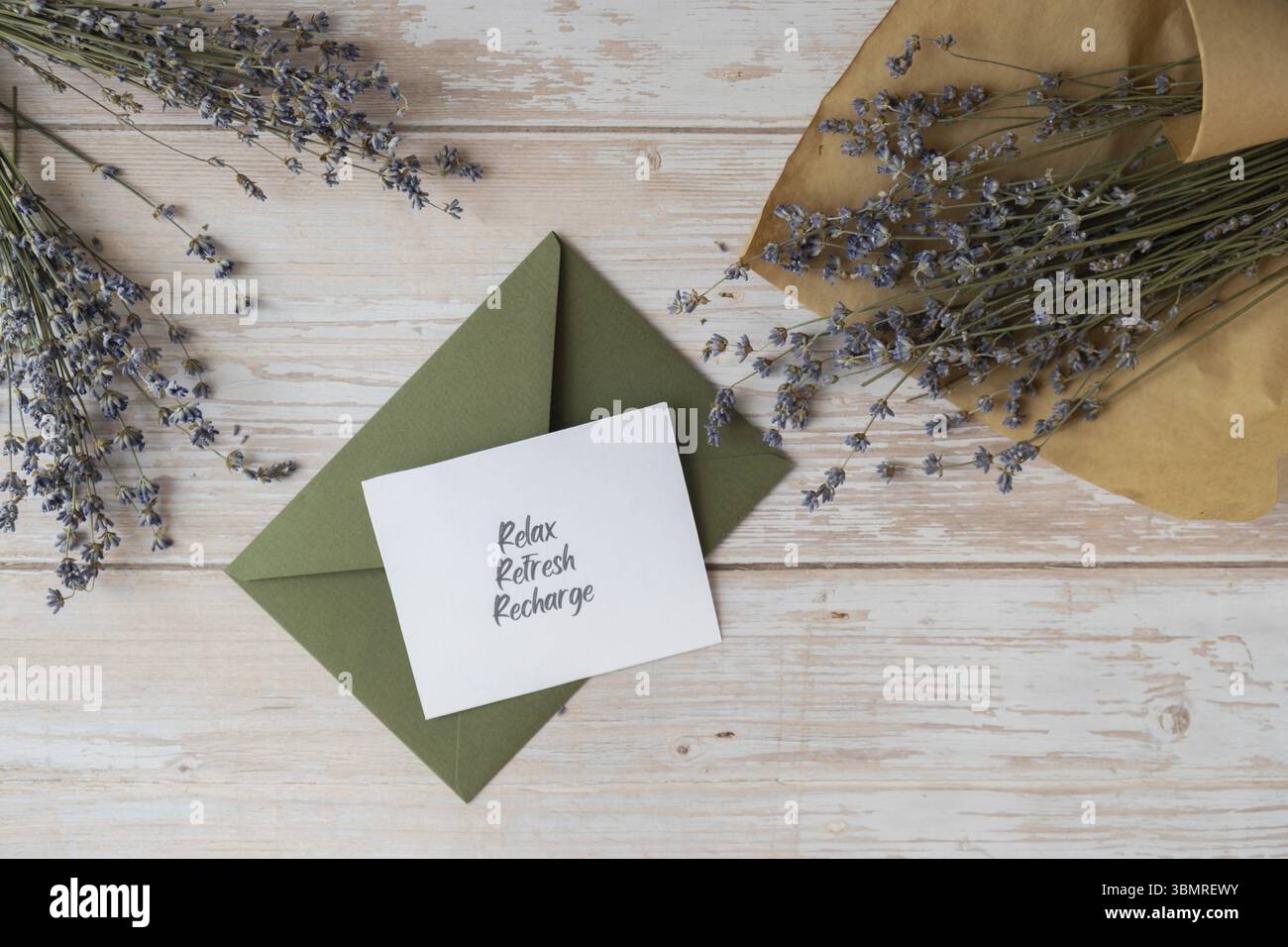 Note de carte papier avec texte RELAX FRESH RECHARGE à partir de l'enveloppe verte. Fleur de lavande. Vue de dessus, pose à plat. Concept de la santé mentale spirituelle auto-voiture Banque D'Images