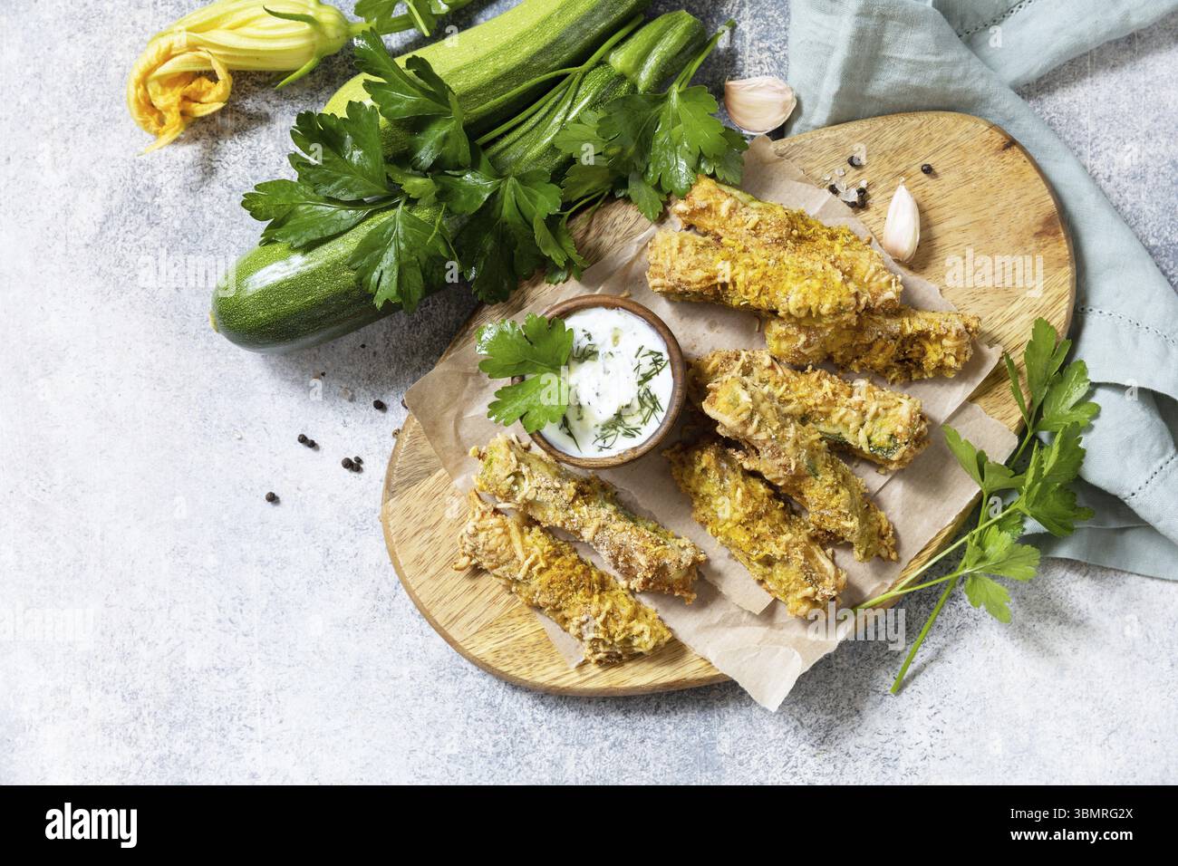 En-cas savoureux et sains, repas d'été. Frites courgettes. Bâtonnets de courgettes croustillants dans de la chapelure, avec du fromage et de la sause à l'ail. Vue de dessus. Copie s Banque D'Images