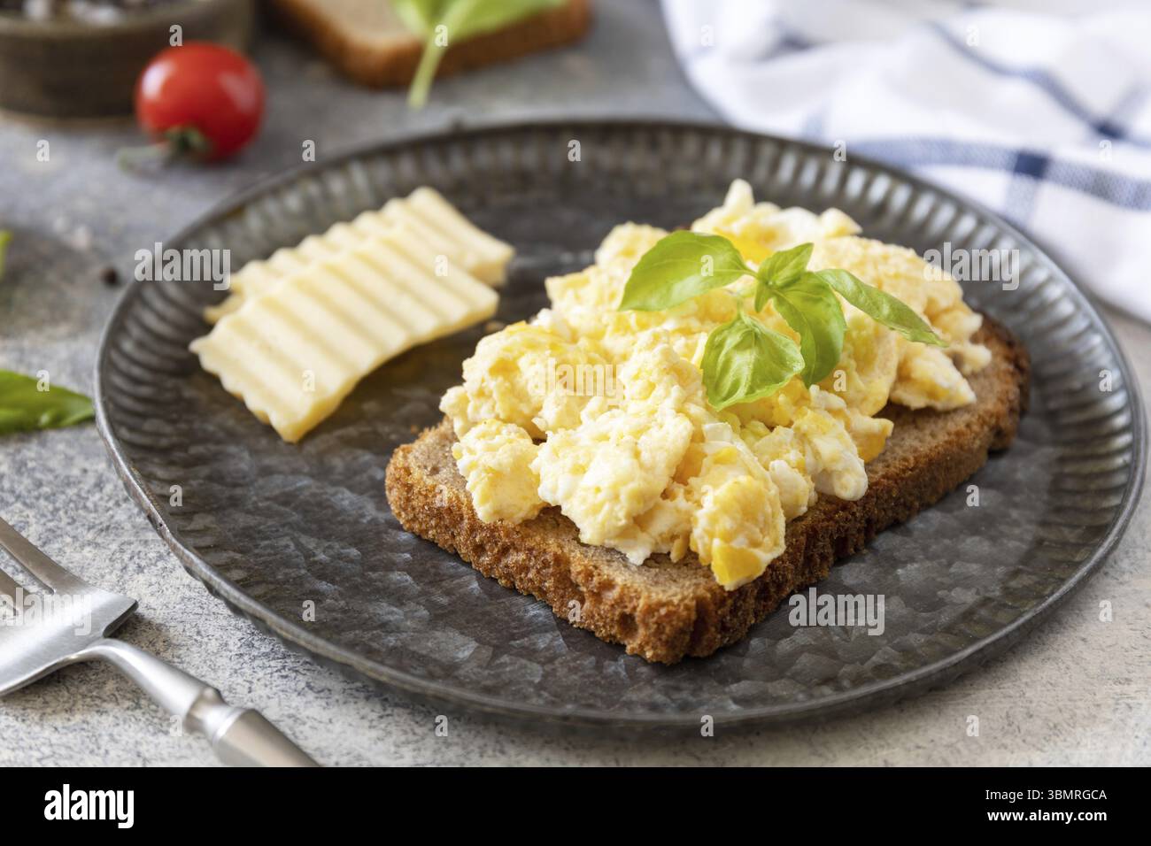 Petit-déjeuner maison ou brunch - œufs brouillés. Oeufs brouillés sur pain de grains entiers sur une table en pierre Banque D'Images