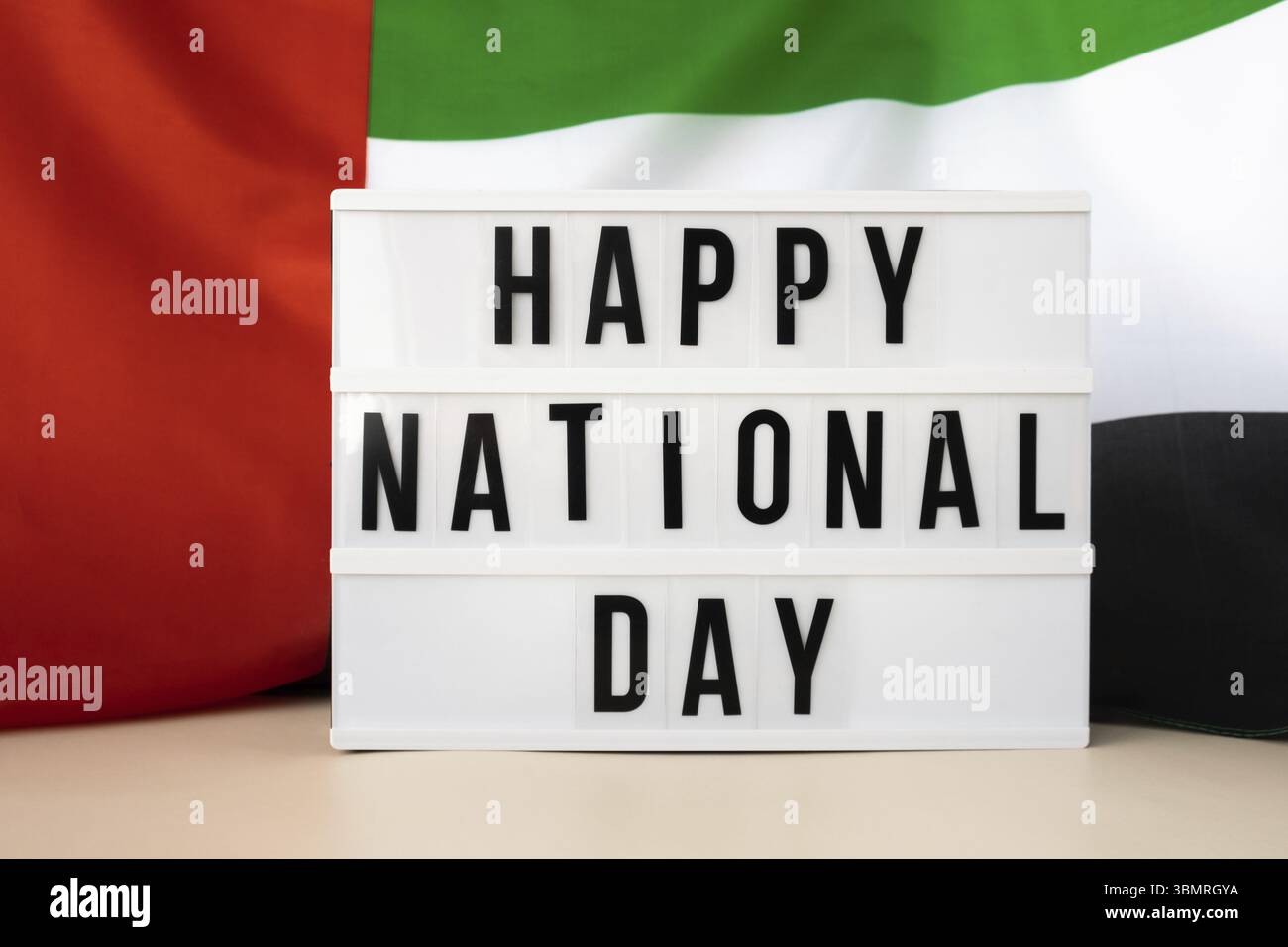 Message HAPPY NATIONAL DAY cadre de texte sur les Émirats arabes Unis agitant le drapeau en tissu de soie. Jour de commémoration de l'indépendance vacances publiques musulmanes Banque D'Images