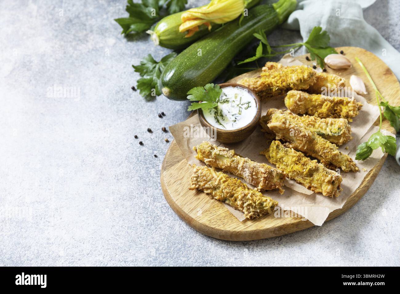 Collation saine et savoureuse, repas d'été. Frites de courgettes. Bâtonnets de courgettes croustillantes dans de la chapelure, avec du fromage et de la saucisse au yaourt à l'ail. Copier l'espace Banque D'Images
