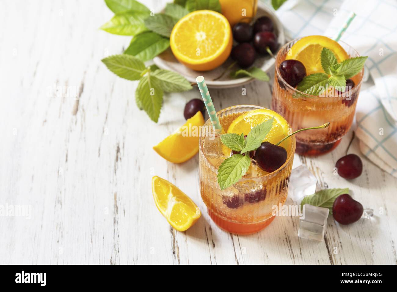 Boisson rafraîchissante glacée limonade de cola cerise orange ou cocktail mojito en verre sur une table en bois. Boisson fraîche d'été. Espace de copie Banque D'Images