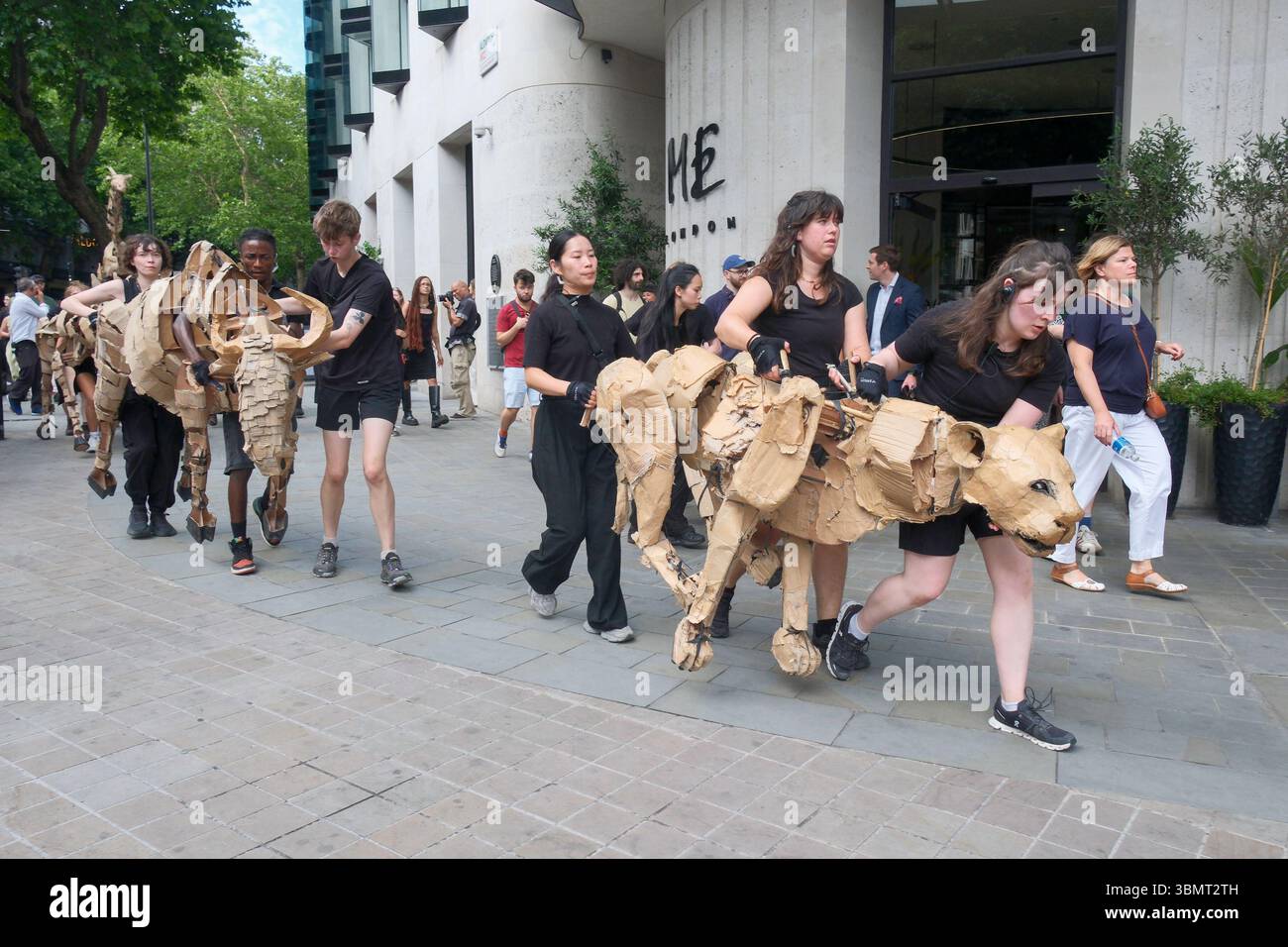 Londres, Royaume-Uni. 27 juin 2025. The Herds, une initiative d’art public et d’action climatique dans laquelle des animaux marionnettes grandeur nature créés à partir de matériaux recyclés parcourent 20 000 km du bassin du Congo au cercle arctique, symbolisant leur fuite des catastrophes climatiques à travers les villes d’Afrique et d’Europe. Sur la photo : les marionnettistes manipulent des marionnettes d'animaux grandeur nature alors que les troupeaux se fraient un chemin dans les rues du centre de Londres. Banque D'Images
