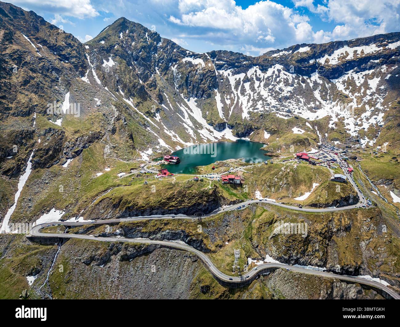 Vue aérienne du lac alpin Balea et de la route courbe Transfagarasan. Photo drone prise le 8 juin 2025, comté de Sibiu, Roumanie. Banque D'Images