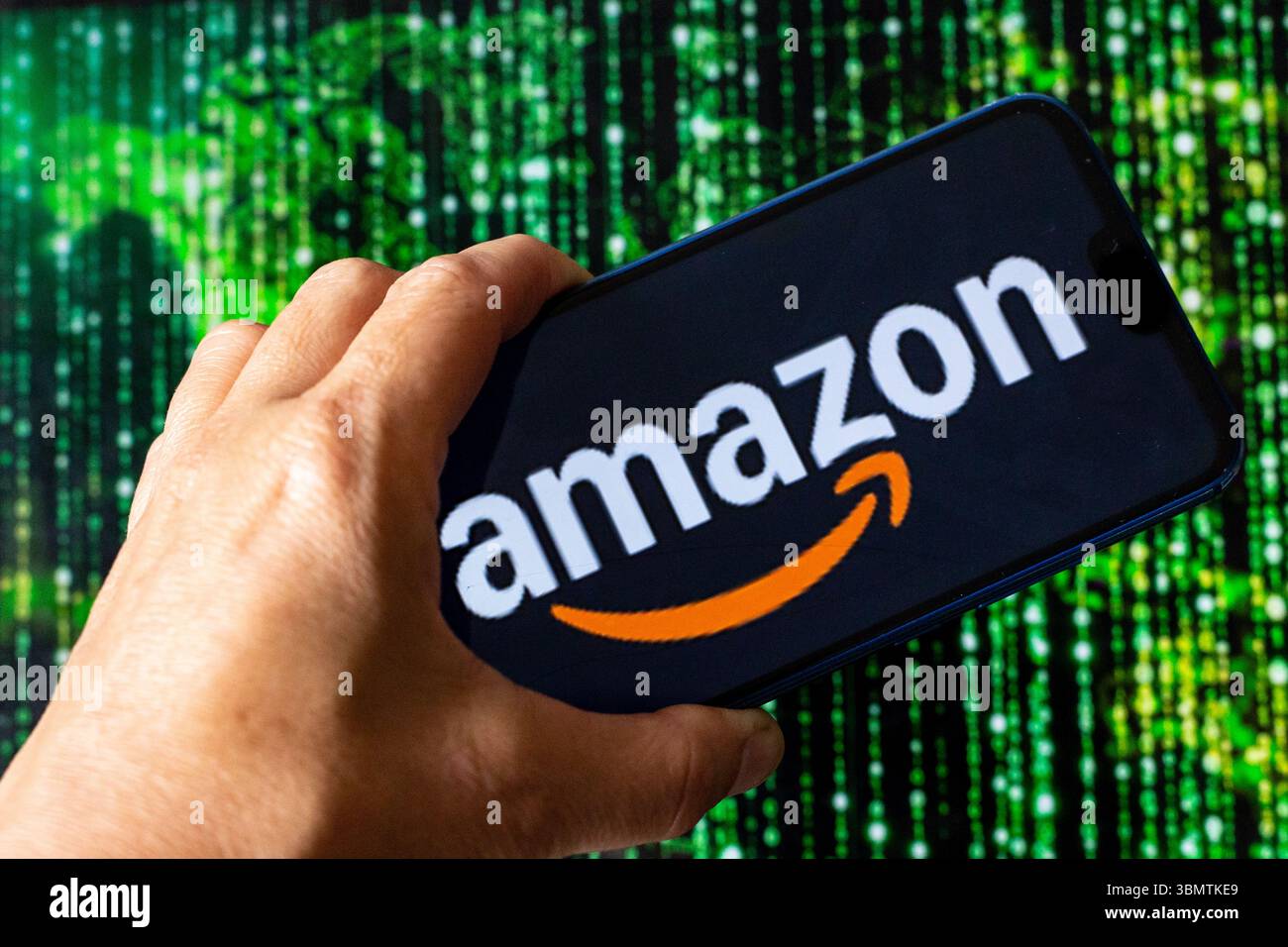 Dans cette illustration de photo, le logo Amazon est montré sur un téléphone portable contre l'illustration d'une carte du monde et illustration matricielle affichée sur un écran d'ordinateur alors qu'Amazon construit le plus grand superordinateur jusqu'à présent aux États-Unis. Banque D'Images