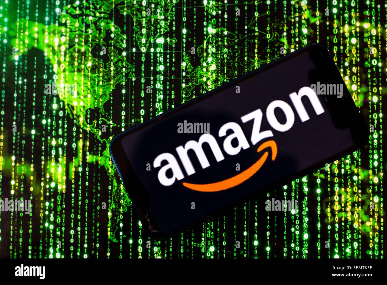 Dans cette illustration de photo, le logo Amazon est montré sur un téléphone portable contre l'illustration d'une carte du monde et illustration matricielle affichée sur un écran d'ordinateur alors qu'Amazon construit le plus grand superordinateur jusqu'à présent aux États-Unis. Banque D'Images