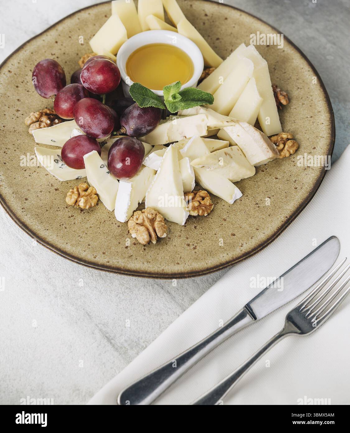 Nature morte de nourriture, assiette de fromage servie avec vin et miel vue de dessus Banque D'Images
