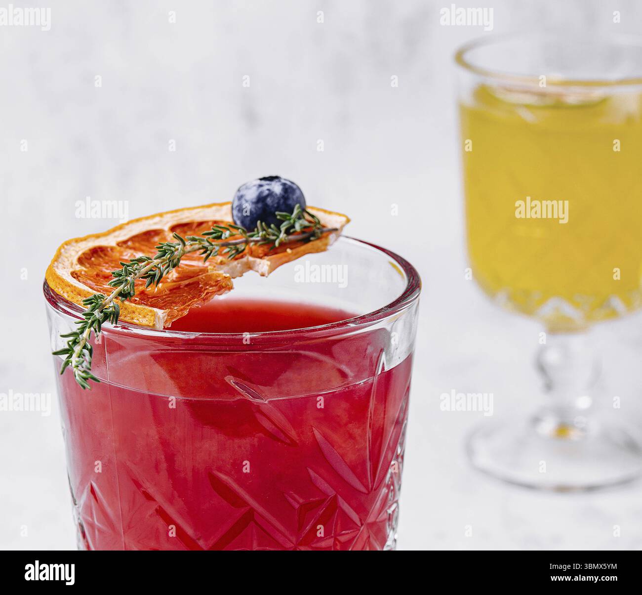 Nature morte, cocktail de margarita à l'orange sanguine avec glace et thym Banque D'Images