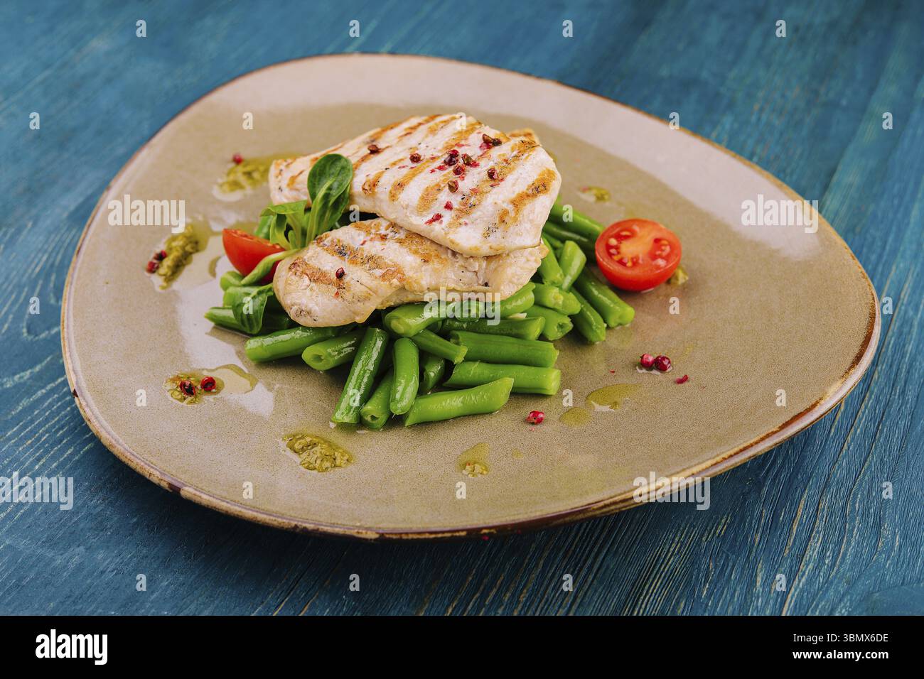 Natures mortes, filets de poulet grillés sur haricots verts Banque D'Images