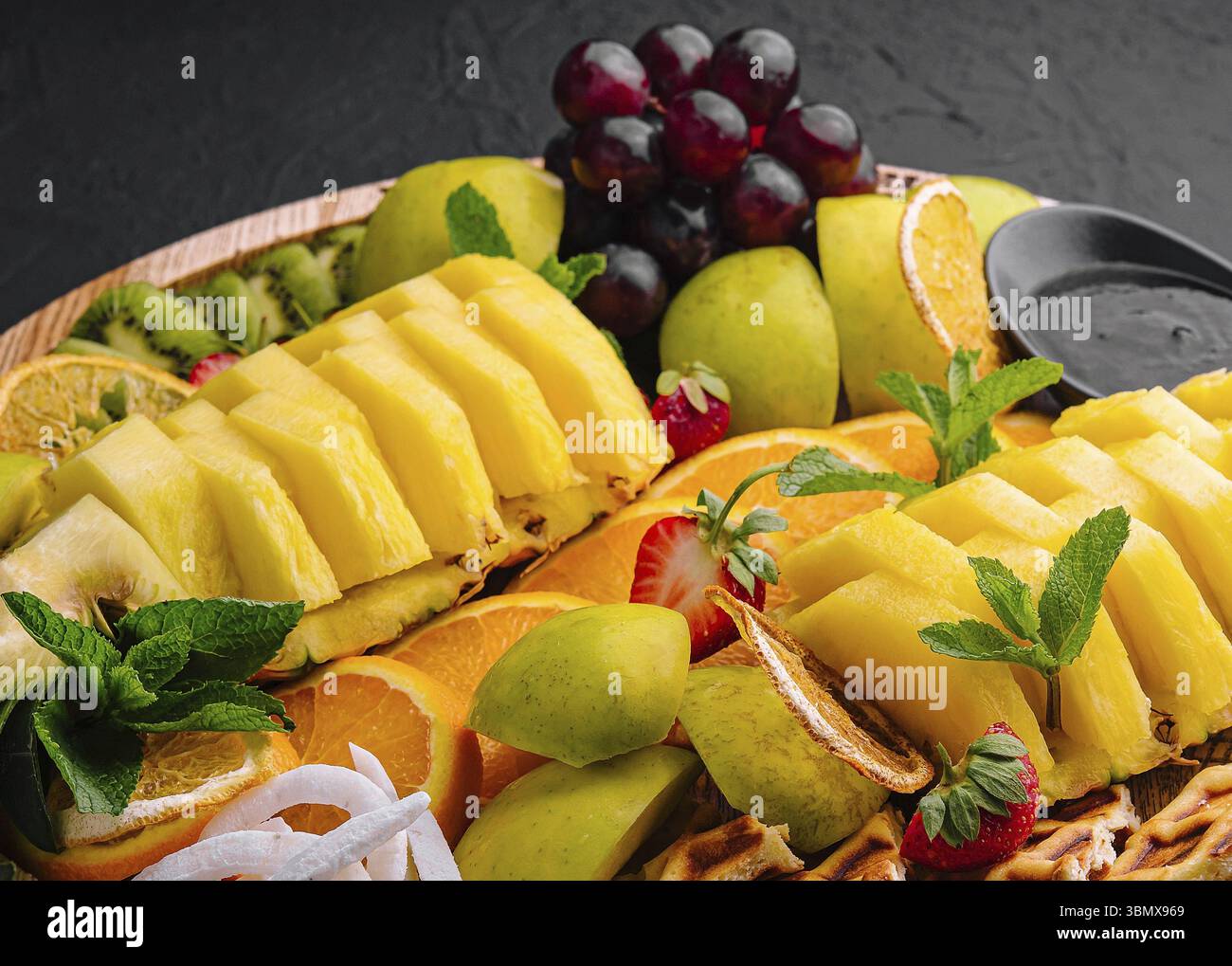 Nourriture morte-vie, Une assiette de fruits assortie sur pierre noire Banque D'Images