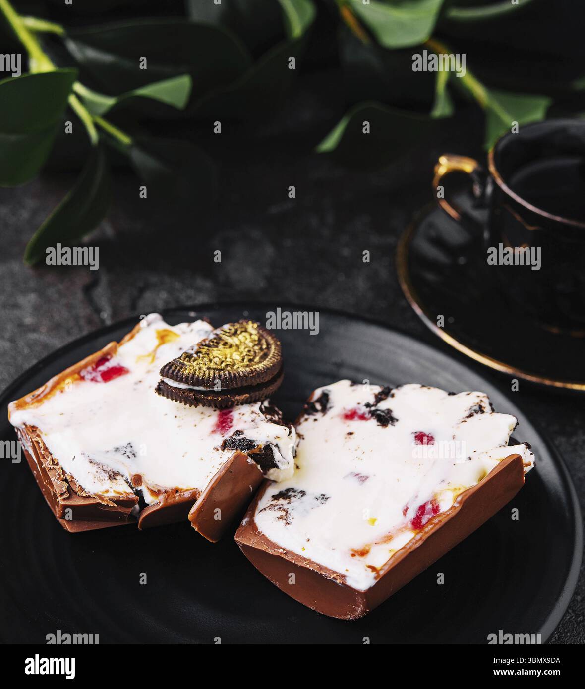 Nourriture Still-Life, tasse de chocolat tranchée Oreo sur assiette noire Banque D'Images