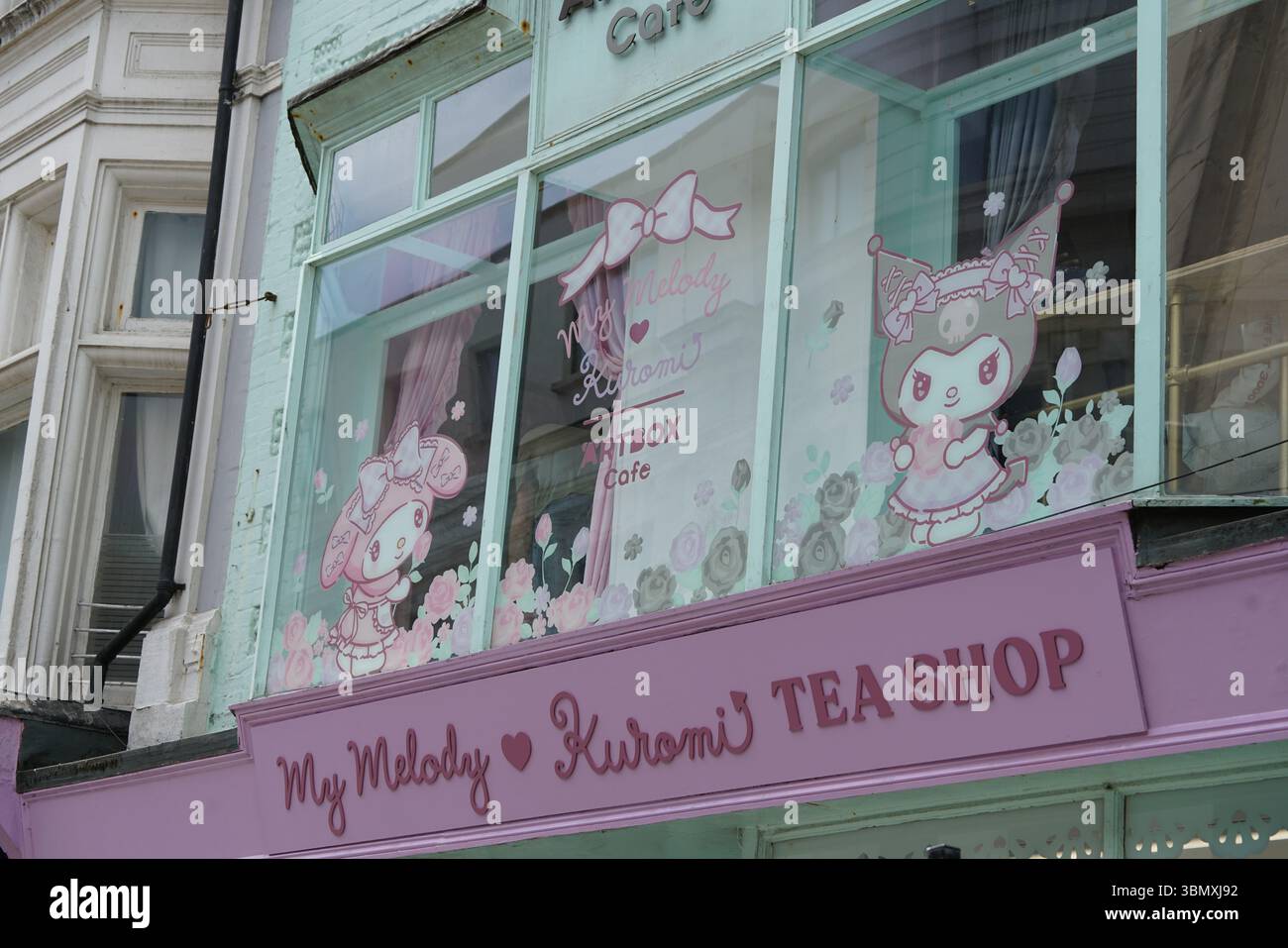 Joli affichage de dessin animé pastel avec lapin et desserts sur la fenêtre en verre. Brighton, Angleterre Banque D'Images