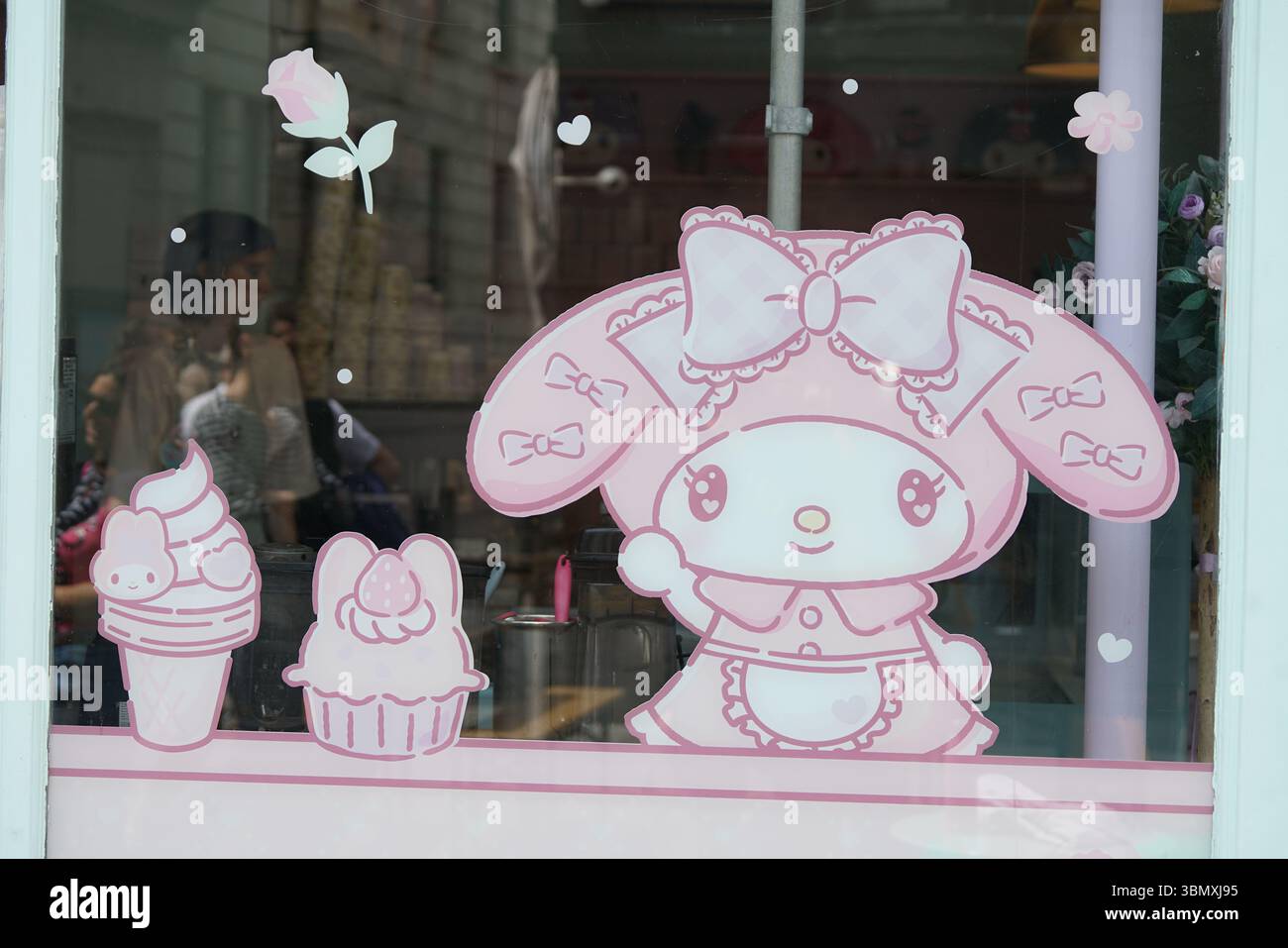 Joli affichage de dessin animé pastel avec lapin et desserts sur la fenêtre en verre. Brighton, Angleterre Banque D'Images
