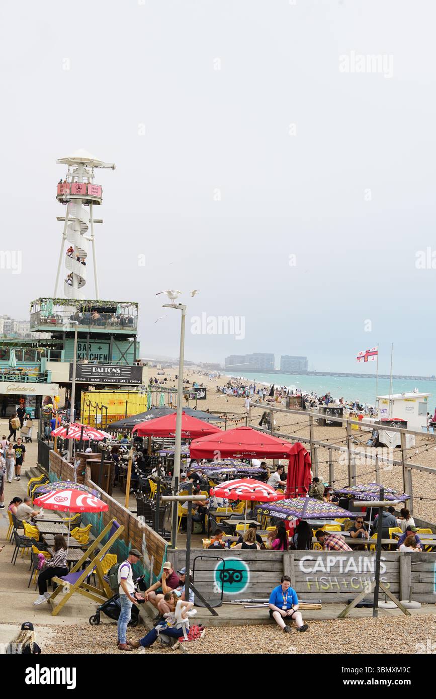 Seaside Cafe avec plage bondée et clients du restaurant sous parasols. Brighton, Angleterre Banque D'Images