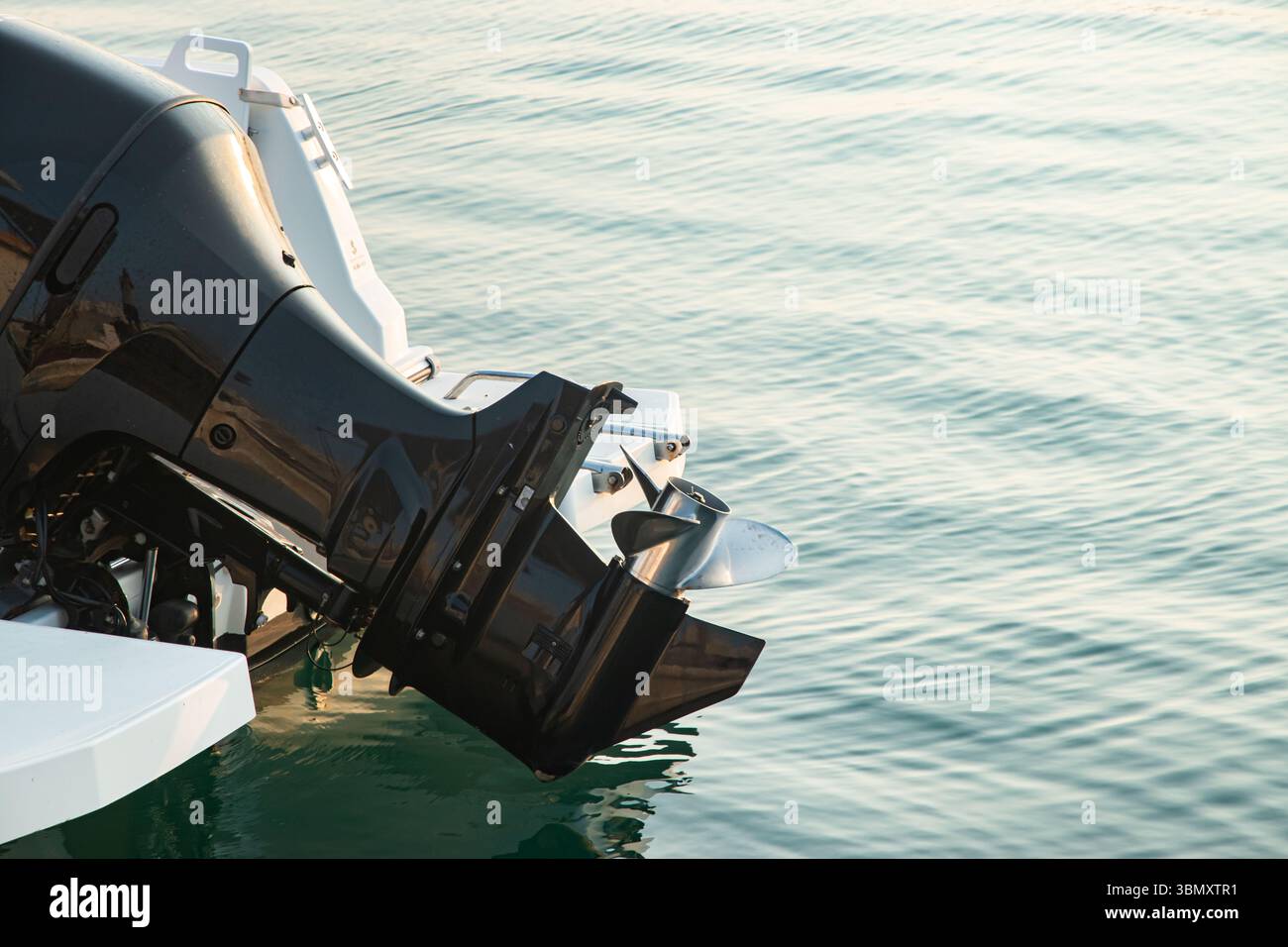 Gros plan du moteur hors-bord sur un bateau moderne dans l'eau de mer calme Banque D'Images