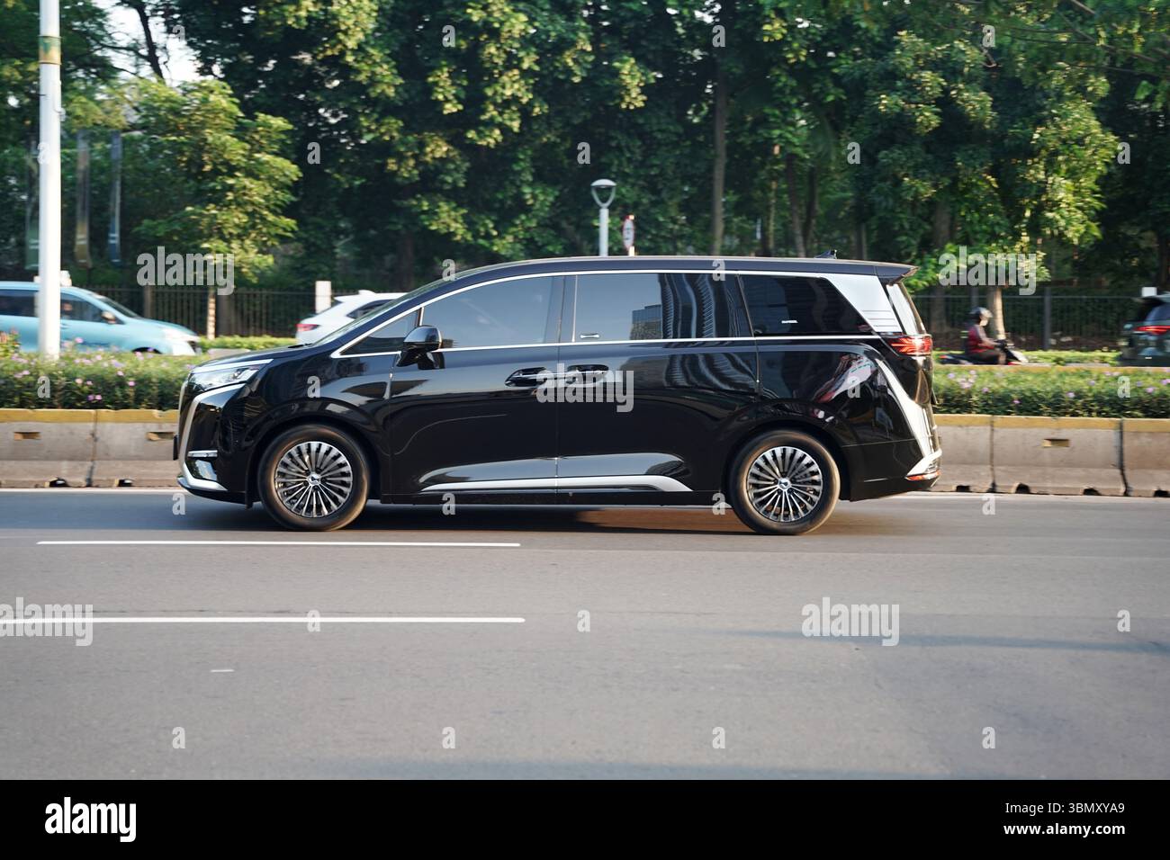 Voiture électrique de luxe MPV BYD Denza D9, couleur sombre conduite dans la zone de distriques d'affaires, Sudirman Street, Jakarta, Indonésie Banque D'Images