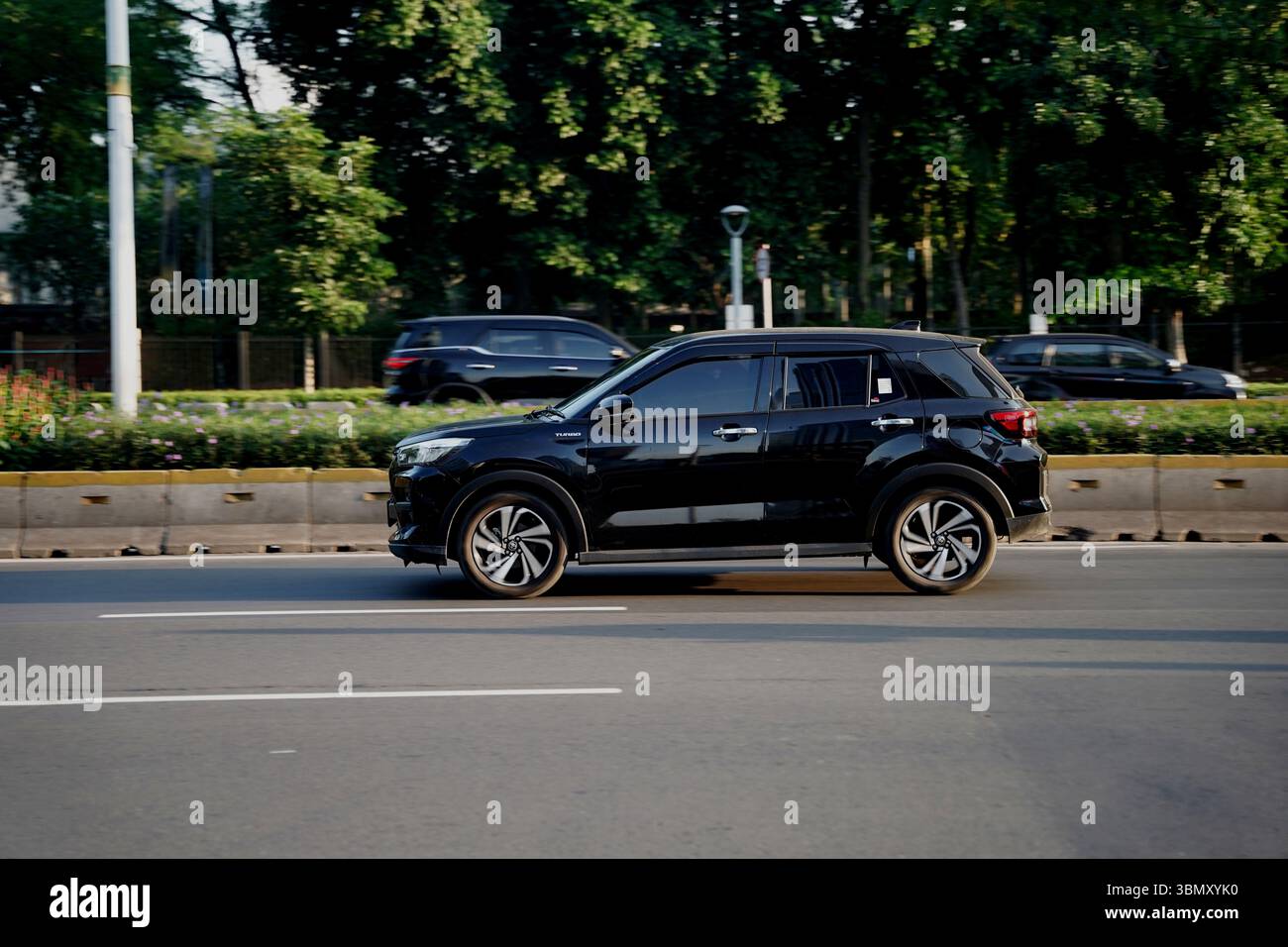 SUV Toyota Raize, couleur foncée conduite dans la zone de distric d'affaires, Sudirman Street, Jakarta, Indonésie Banque D'Images