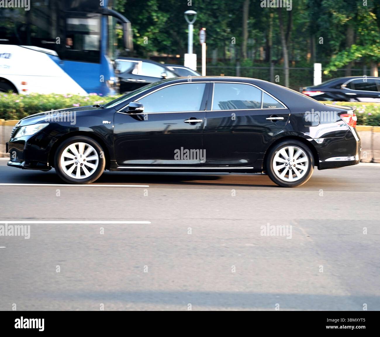 Berline de luxe Toyota Camry, couleur noire à la zone de distric d'affaires, Sudirman Street, Jakarta, Indonésie Banque D'Images
