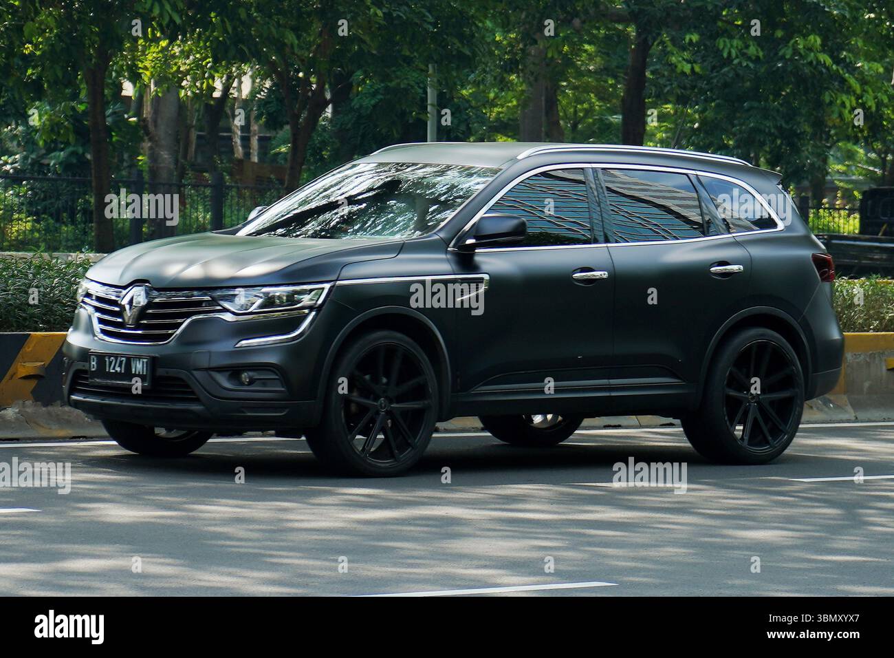 SUV de luxe Renault Koleos, couleur foncée conduite dans la zone de distriques d'affaires, Sudirman Street, Jakarta, Indonésie Banque D'Images