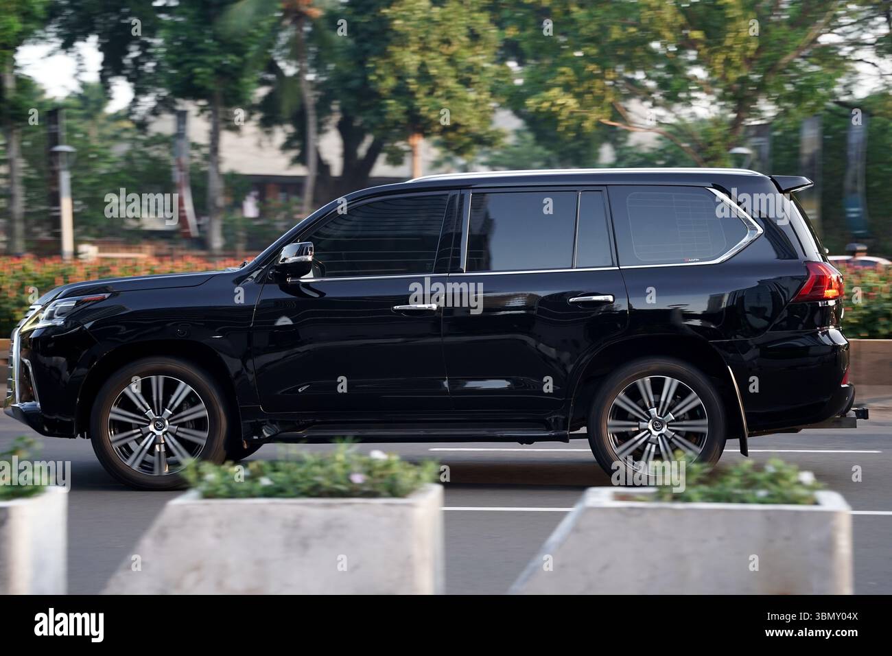 SUV de luxe Lexus LX 570, couleur sombre au quartier des affaires, Sudirman Street, Jakarta, Indonésie Banque D'Images