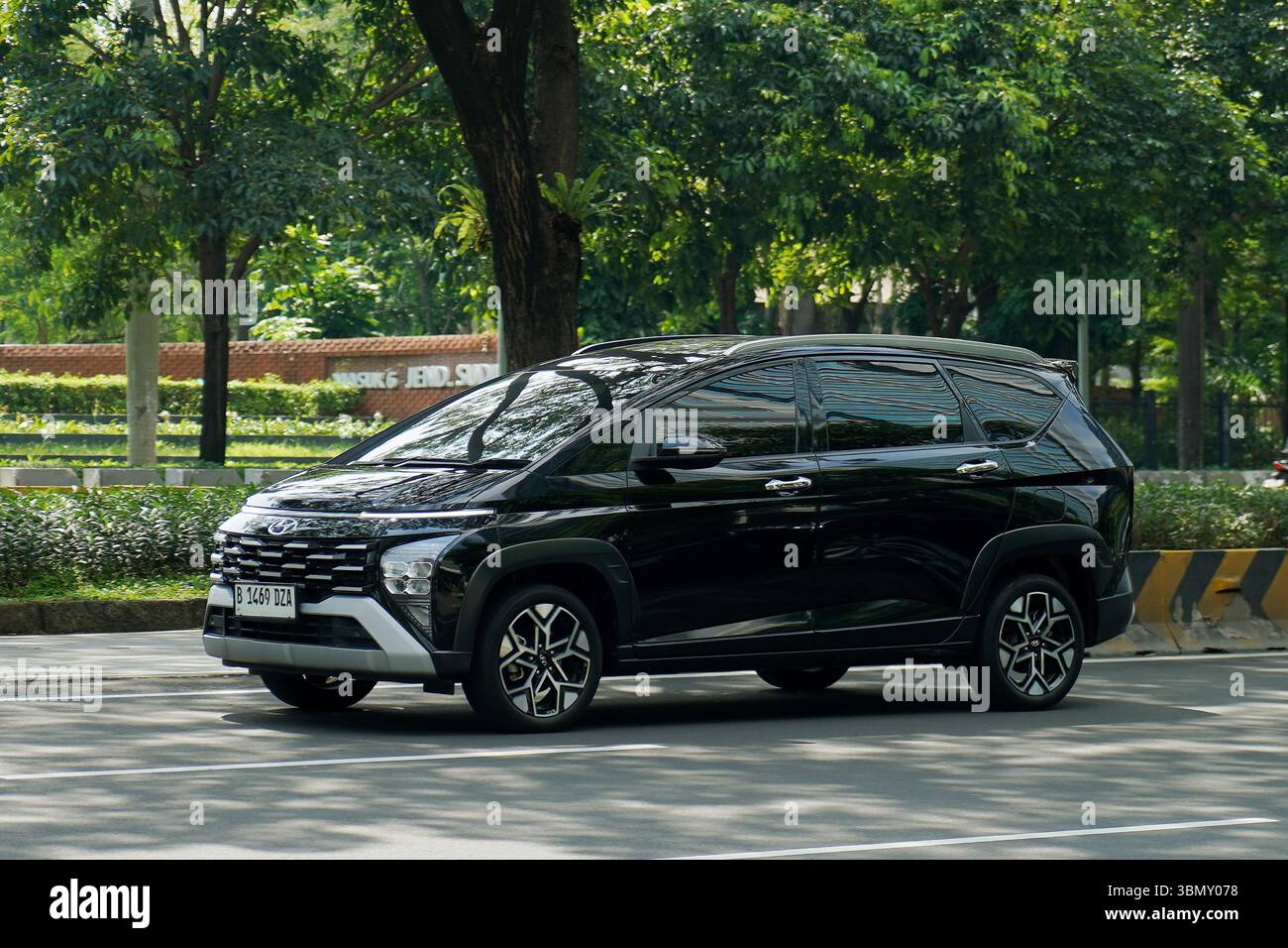 Monospace Hyundai Stargazer, route de couleur sombre dans le quartier des affaires, Sudirman Street, Jakarta, Indonésie Banque D'Images