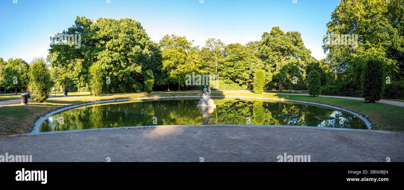 Scène de parc serein avec fontaine au milieu de l'étang réfléchissant entouré d'arbres verts luxuriants à Kildeken, Aalborg, Danemark, 16 juillet 2018 Banque D'Images