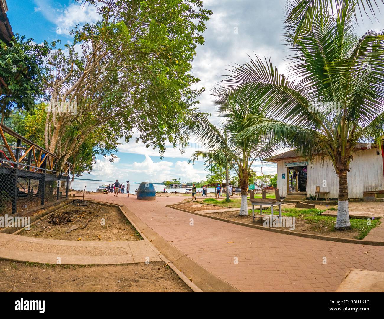 Une scène vibrante à Leticia, Amazonas, mettant en valeur des arbres tropicaux luxuriants et des gens appréciant l'atmosphère extérieure. Banque D'Images