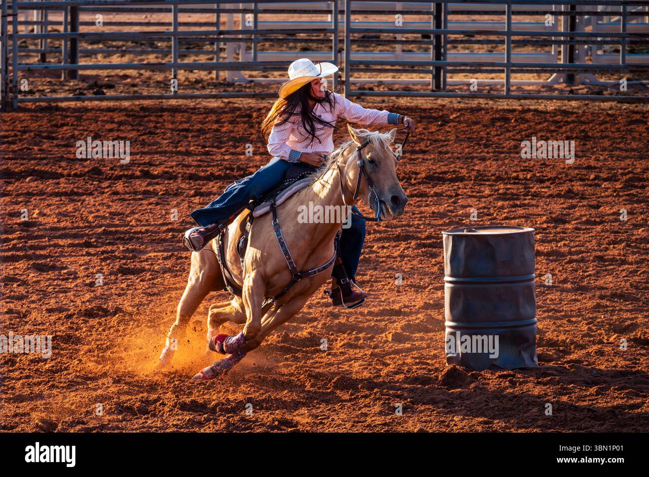 Puissance et grâce sur l'affichage comme cette cowgirl fait un virage serré pendant la course de canon. Banque D'Images