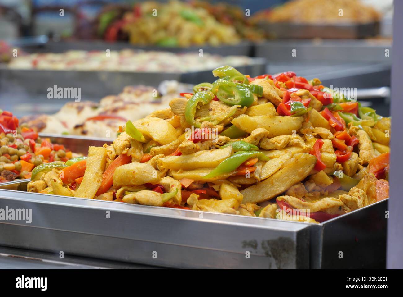 Poulet coloré et légumes sautés au marché Banque D'Images