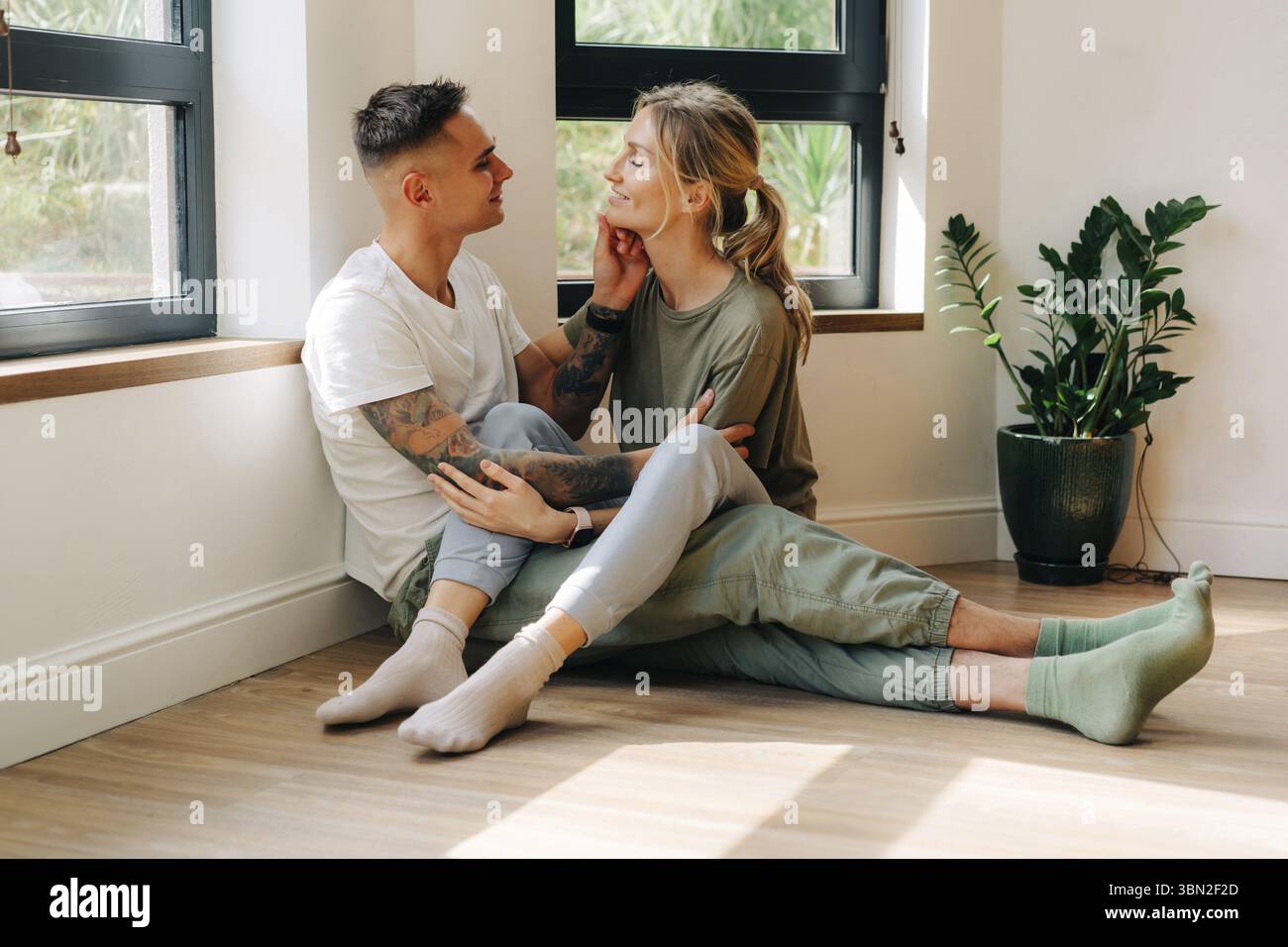 Jeune couple d'amoureux caucasiens passent du temps assis sur le sol dans le salon Banque D'Images
