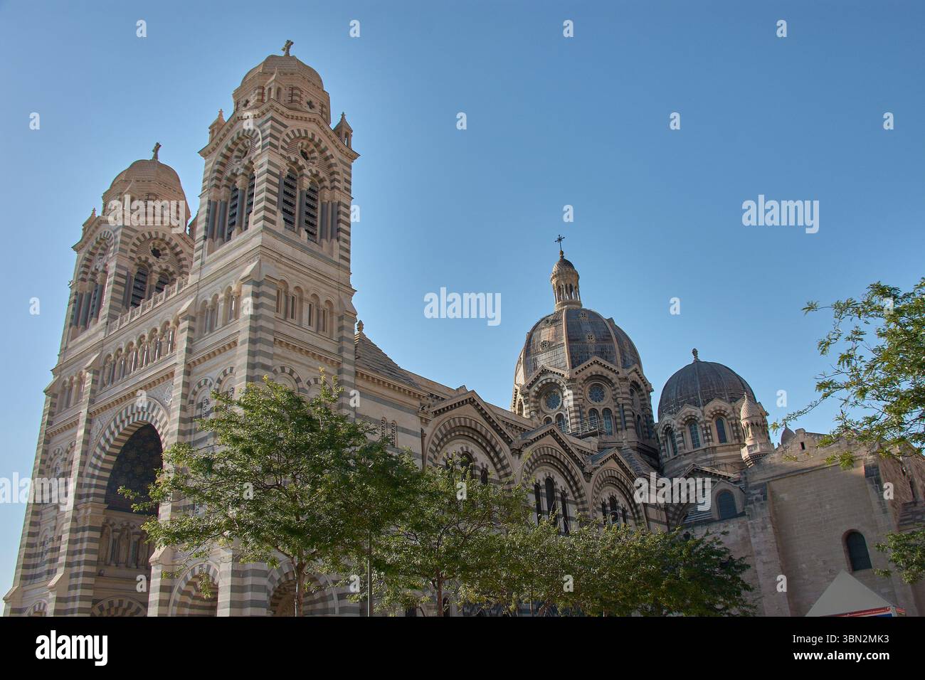 La cathédrale de Marseille, Sainte-Marie-majeure, s’élève avec ses grands dômes en pierre et ses tours bicolores, soulignant la monumentalité de son néo-byzantine Banque D'Images