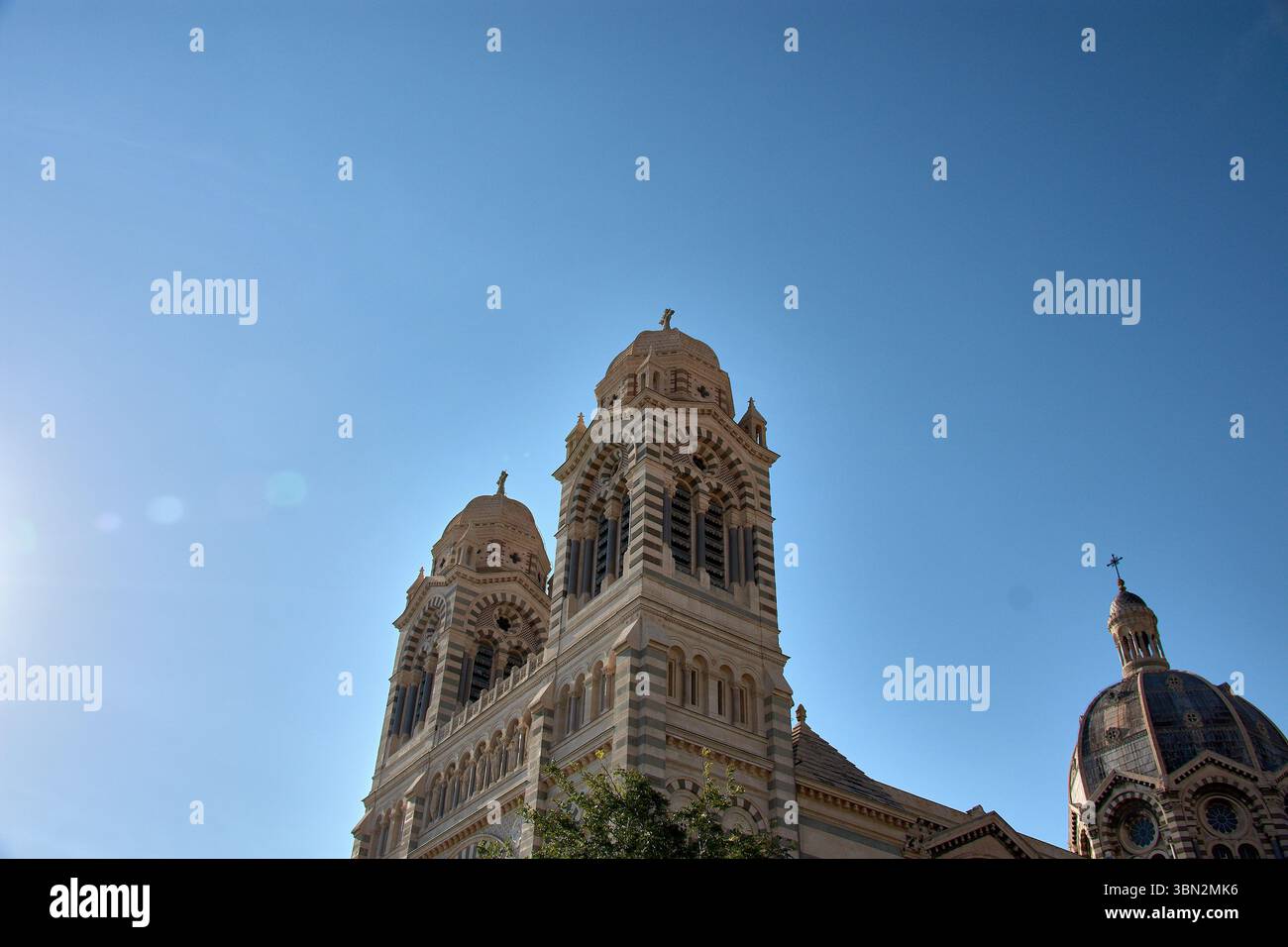 La cathédrale de Marseille, Sainte-Marie-majeure, s’élève avec ses grands dômes en pierre et ses tours bicolores, soulignant la monumentalité de son néo-byzantine Banque D'Images