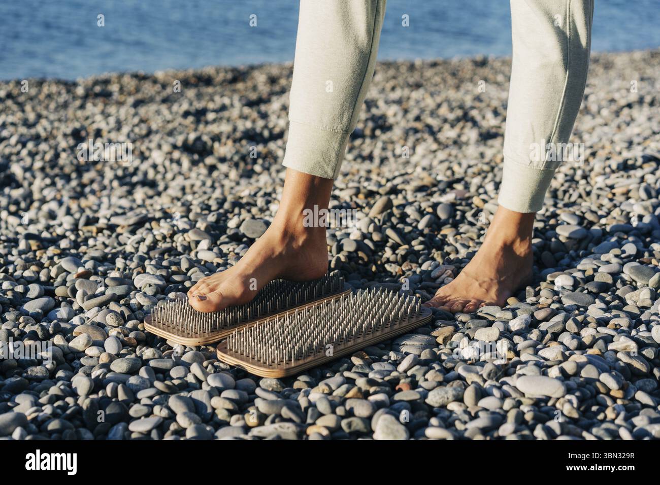 Gros plan d'un pied sur une planche avec des clous, pratique spirituelle de l'acupuncture et de l'acupression Banque D'Images