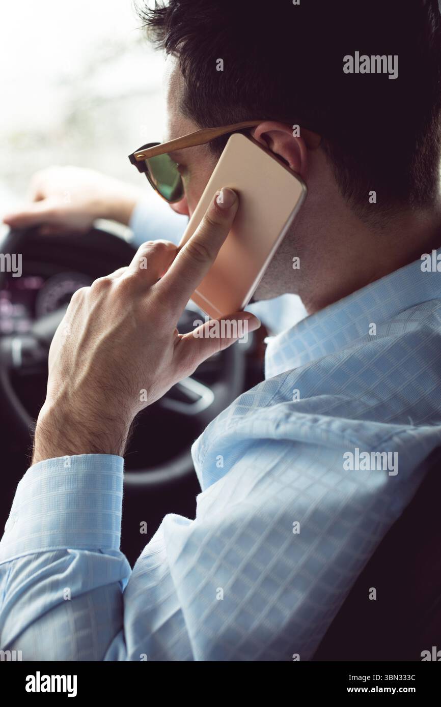 Homme pilote à l'aide de smart phone in car Banque D'Images