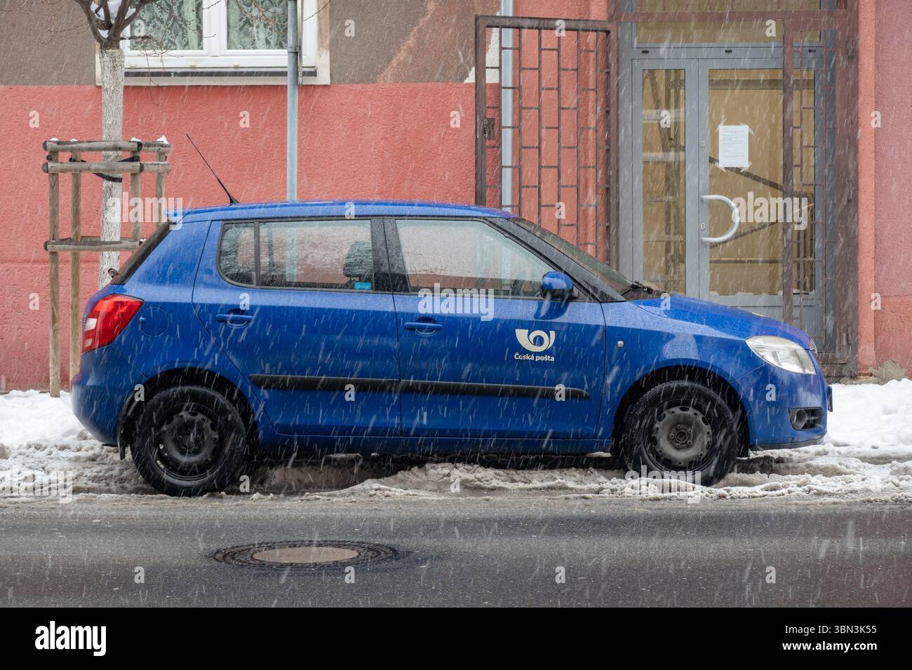 Ostrava, République tchèque - 6 décembre 2023 : Blue Skoda Fabia II du bureau de poste de Ceska Posta garé dans la rue en hiver quand il neige Banque D'Images