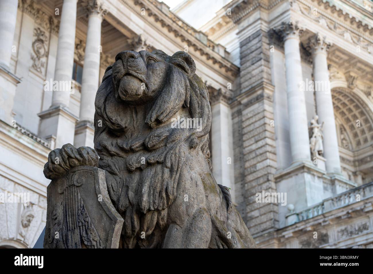 VIENNE, AUTRICHE - 11 AOÛT 2024 - Une sculpture de lion en pierre devant le palais de justice néo-renaissance (Justizpalast) à Vienne. Banque D'Images
