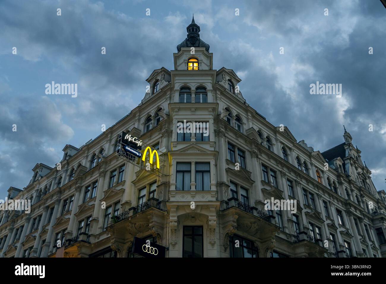 VIENNE, AUTRICHE - 11 AOÛT 2024 - Un bâtiment classique de Vienne arborant des logos de multinationales, symbole de la culture de consommation moderne. Banque D'Images