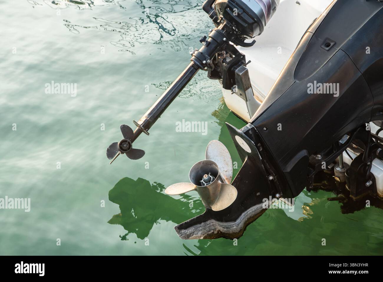 Gros plan du moteur hors-bord sur un bateau moderne dans l'eau de mer calme Banque D'Images
