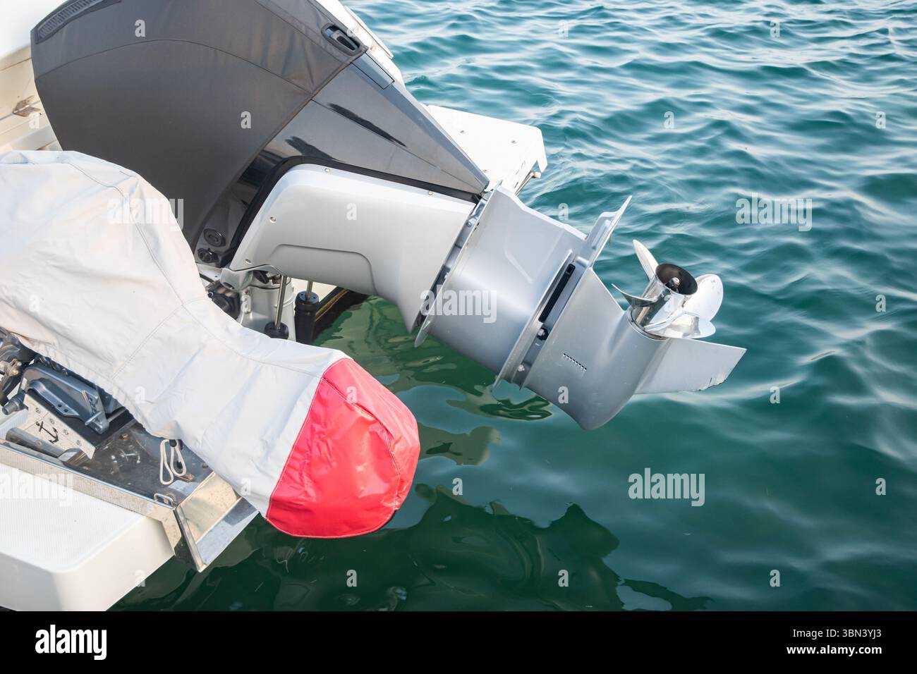 Gros plan du moteur hors-bord sur un bateau moderne dans l'eau de mer calme Banque D'Images