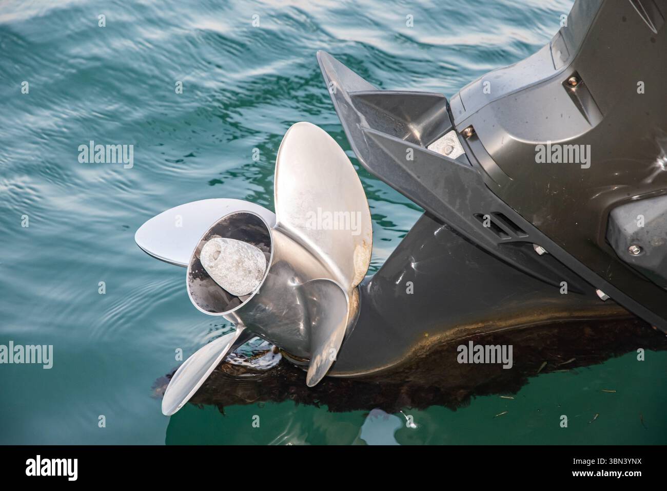 Gros plan du moteur hors-bord sur un bateau moderne dans l'eau de mer calme Banque D'Images