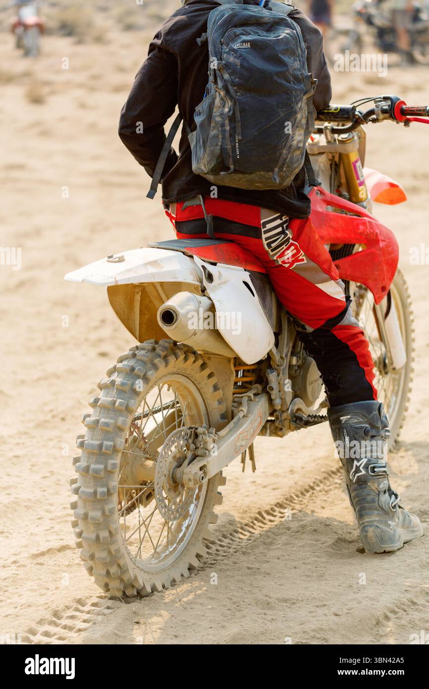 Pilote de motocross prenant une pause sur piste sablonneuse Banque D'Images