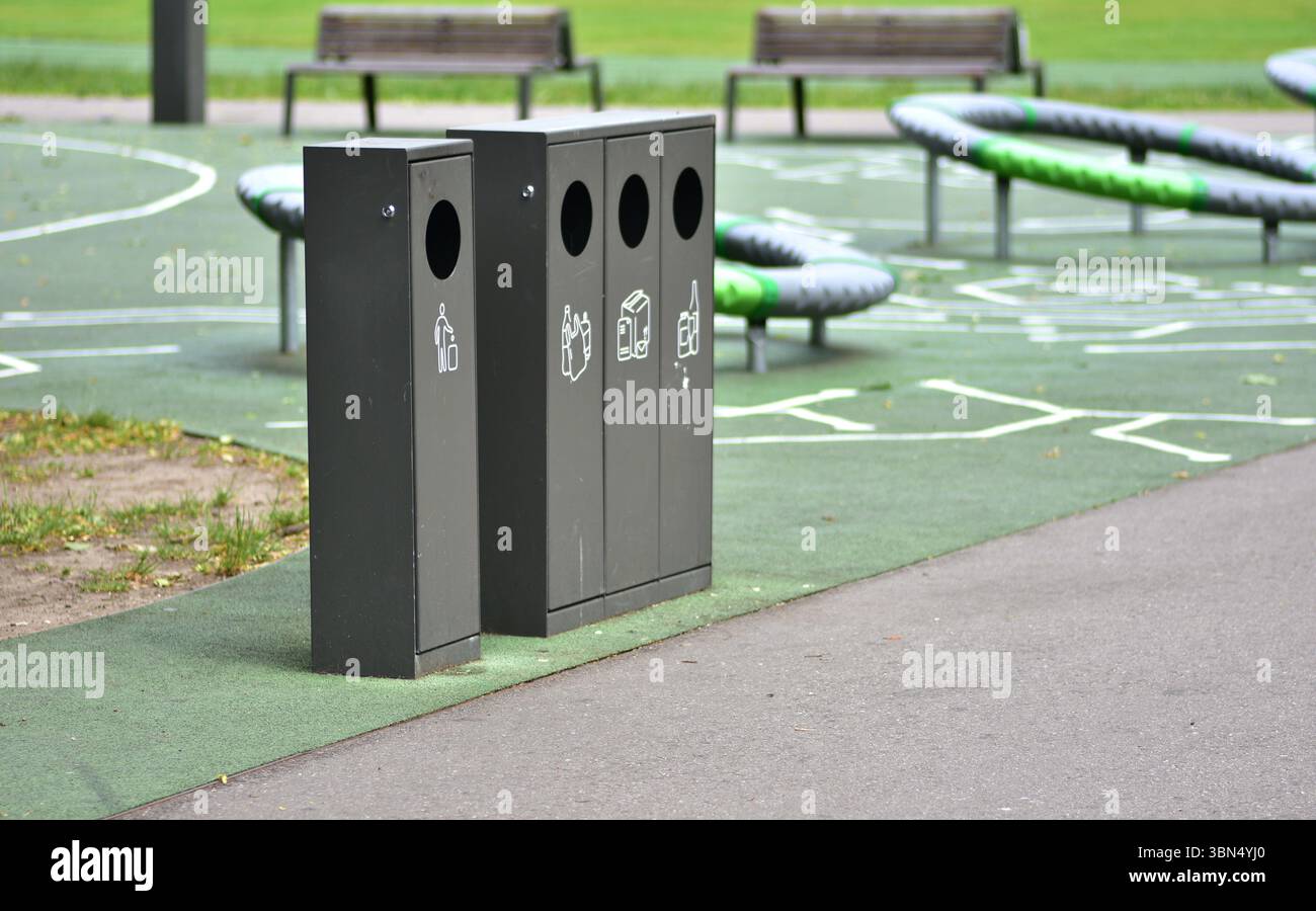 Le tri des poubelles dans un parc public avec des conteneurs séparés pour le plastique, le papier, le verre et les déchets généraux favorise la durabilité et la responsabilité Banque D'Images