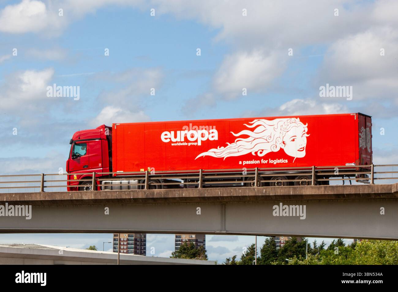 Un camion articulé à rideaux rouges du groupe Europa Worldwide circule sur le contournement de l'A5 à Tamworth, Staffordshire, au Royaume-Uni. Banque D'Images