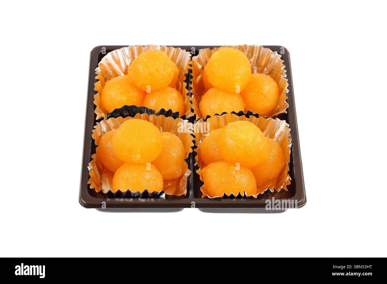 boules de caramel jaune d'oeuf cuites dans du sirop dans une boîte carrée isolée sur blanc, c'est un doux thaïlandais connu sous le nom de tong yod. Banque D'Images