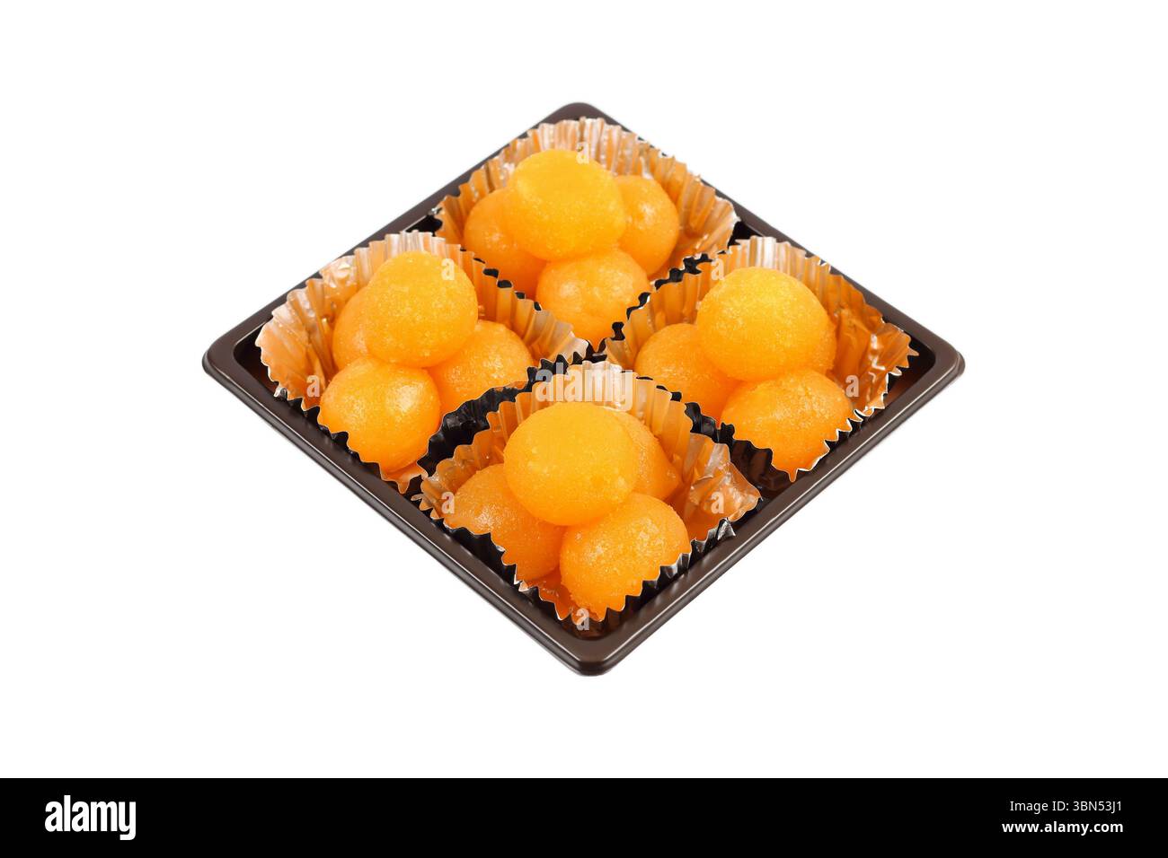 boules de caramel jaune d'oeuf cuites dans du sirop dans une boîte carrée isolée sur blanc, c'est un doux thaïlandais connu sous le nom de tong yod. Banque D'Images