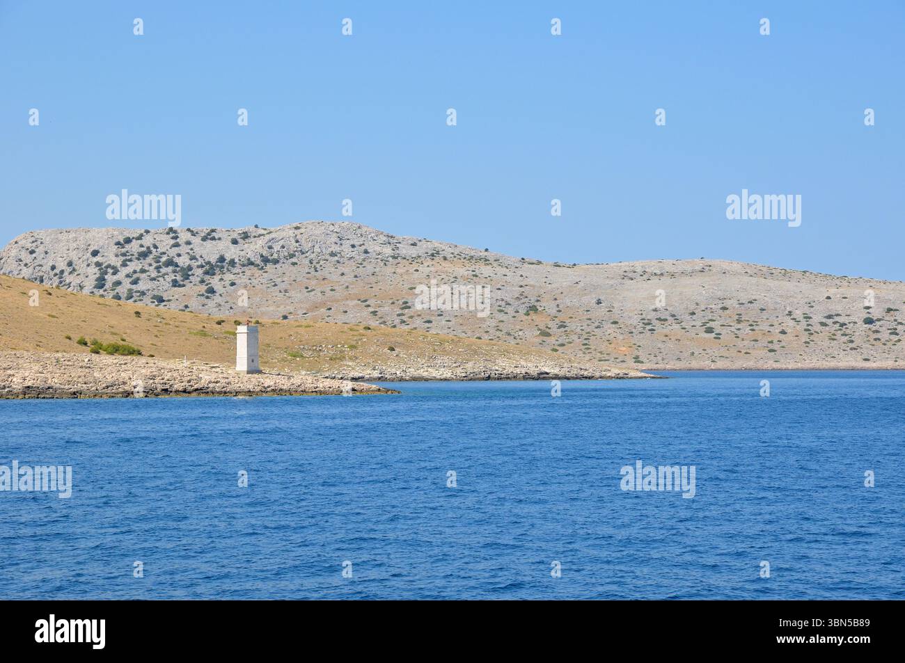 Excursion en bateau dans les célèbres îles Kornati croates, vue du bateau à un phare pittoresque contre le ciel bleu. Banque D'Images